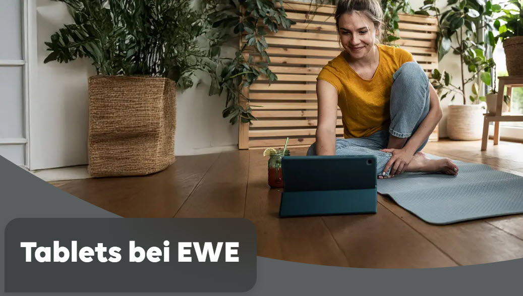Tablets bei EWE Dekoratives Bild. Eine junge Frau sitzt auf einer Yogamatte, vor ihr steht ein Tablet. Im Hintergrund grüne Zimmerplfanzen.